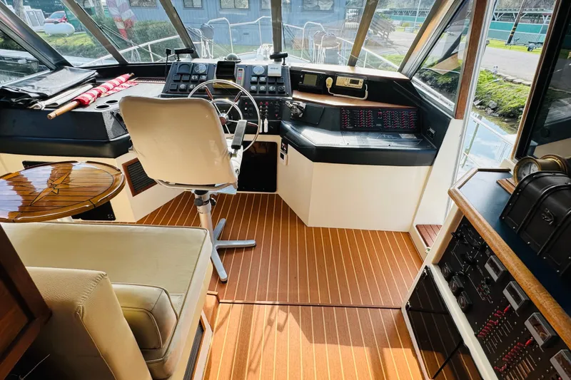 Slide: The Image of 1987 Bayliner 4550 Motoryacht helm with steering wheel, control panel, and captain's chair. - 54