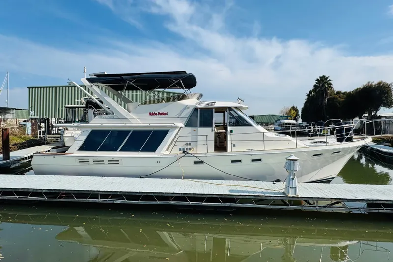 Slide: The Image of 1987 Bayliner 4550 Motoryacht docked at marina under clear blue sky. - 6