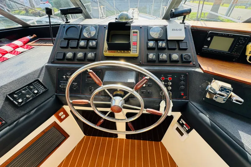 Slide: The Image of 1987 Bayliner 4550 Motoryacht helm with steering wheel and control panels. - 60