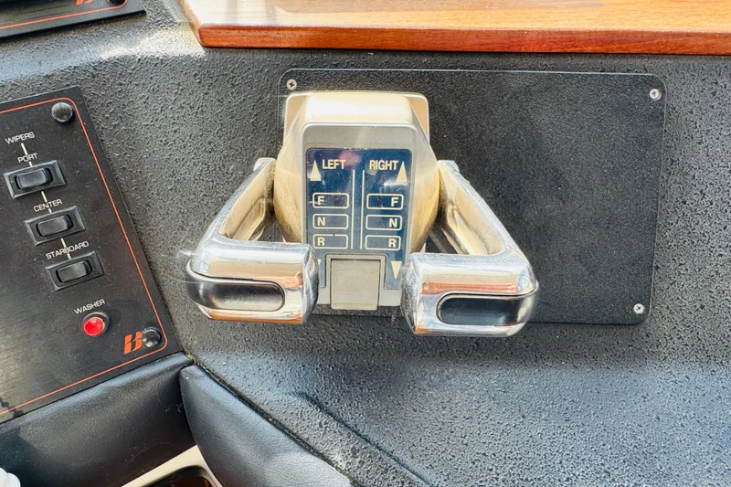 Slide: The Image of 1987 Bayliner 4550 Motoryacht control panel with throttle and wiper switches. - 62