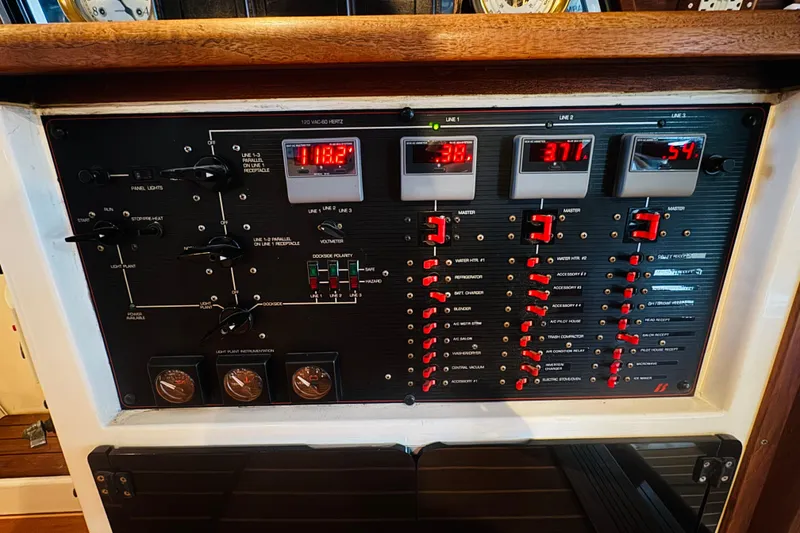 Slide: The Image of Control panel of a 1987 Bayliner 4550 Motoryacht with various switches and digital displays. - 64