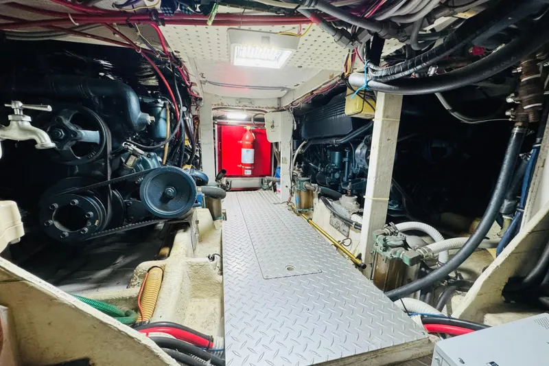 Slide: The Image of Engine room of 1987 Bayliner 4550 Motoryacht with visible machinery and wiring. - 87