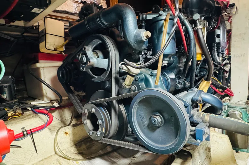 Slide: The Image of Engine compartment of a 1987 Bayliner 4550 Motoryacht, showcasing mechanical components and belts. - 90