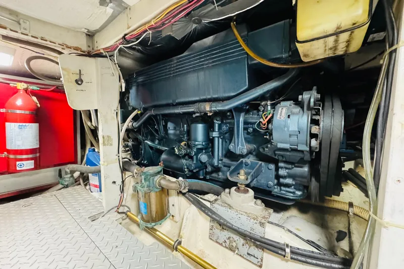Slide: The Image of Engine room of 1987 Bayliner 4550 Motoryacht with visible machinery and fire extinguisher. - 91
