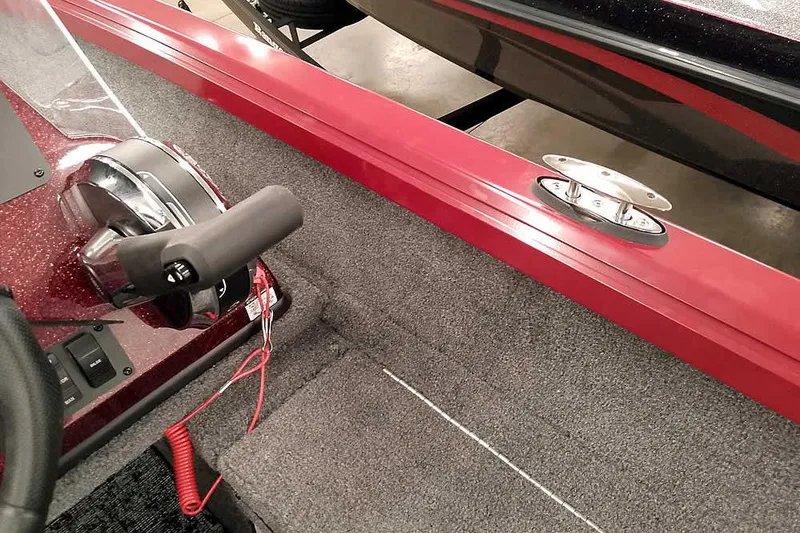 Slide: The Image of Interior of 2026 Ranger Aluminum VS1665 SC boat with red accents and control panel. - 24