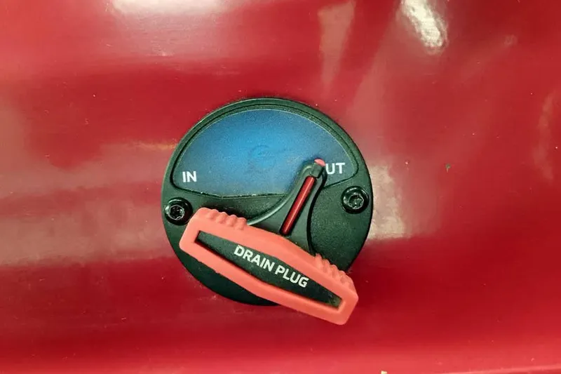 Slide: The Image of Red drain plug on 2026 Ranger Aluminum VS1665 SC boat, labeled "IN" and "OUT." - 26