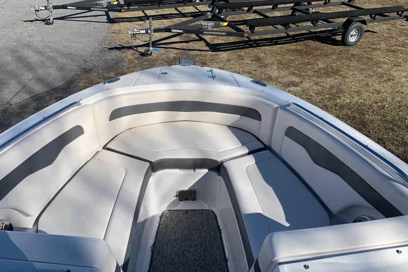 Slide: The Image of 2015 Chaparral 246 SSi boat interior with cushioned seating and trailer in background. - 3