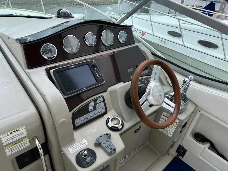 Slide: The Image of 2012 Sea Ray Sundancer helm with gauges, GPS, and wooden steering wheel. - 12