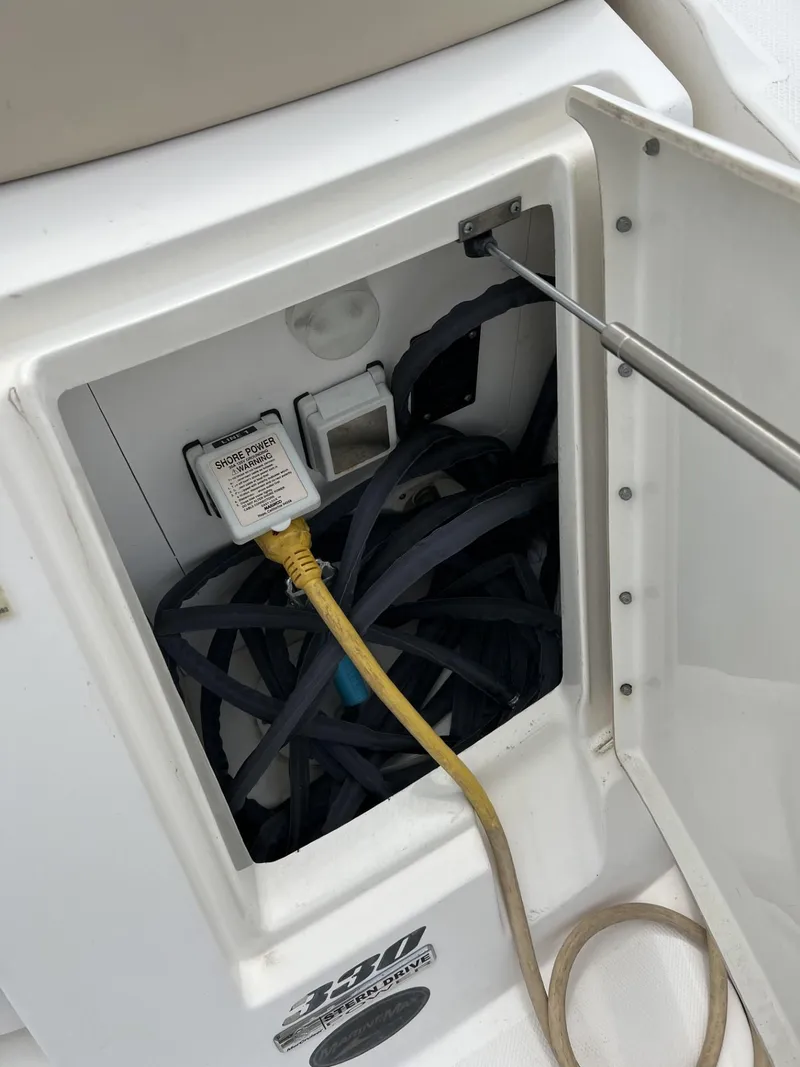 Slide: The Image of 2012 Sea Ray Sundancer storage compartment with cables and electrical connections. - 17