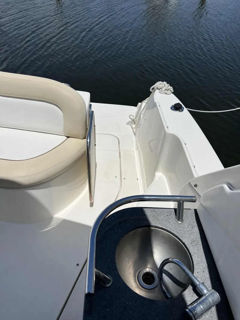 Slide: The Image of 2012 Sea Ray Sundancer boat deck with seating and sink, docked on calm water. - 20