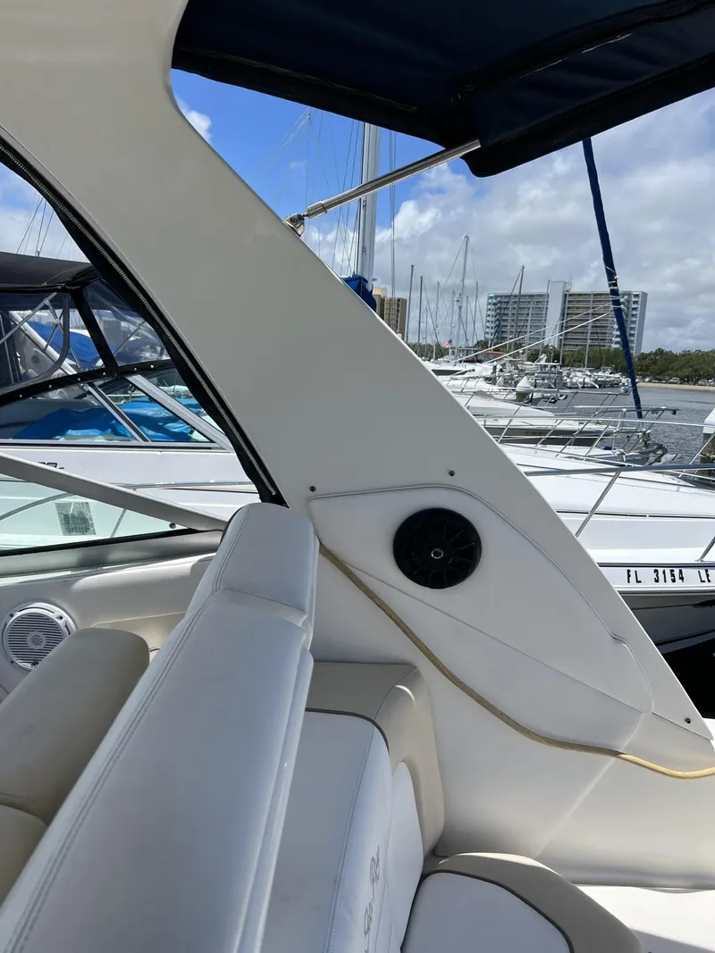 Slide: The Image of 2012 Sea Ray Sundancer interior with marina view, featuring white seating and speaker. - 21