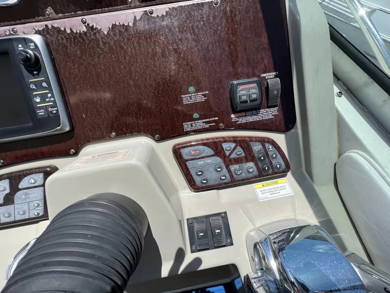 Slide: The Image of Control panel of a 2012 Sea Ray Sundancer boat with various switches and displays. - 25