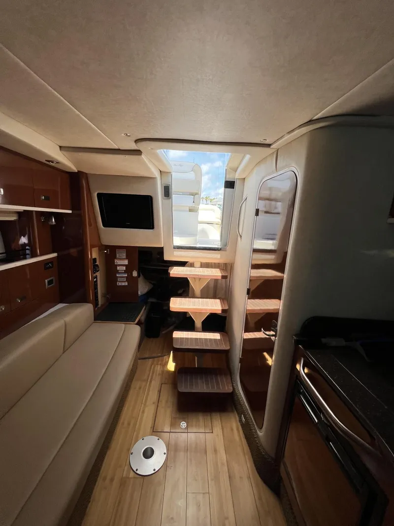 Slide: The Image of Interior of 2012 Sea Ray Sundancer yacht with modern furnishings and wooden flooring. - 31