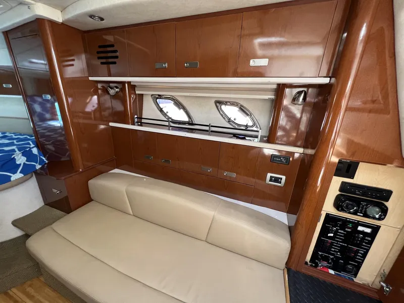 Slide: The Image of Interior of 2012 Sea Ray Sundancer yacht with beige seating and wooden cabinetry. - 33