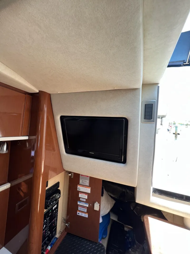 Slide: The Image of 2012 Sea Ray Sundancer interior with mounted TV and control panel. - 34