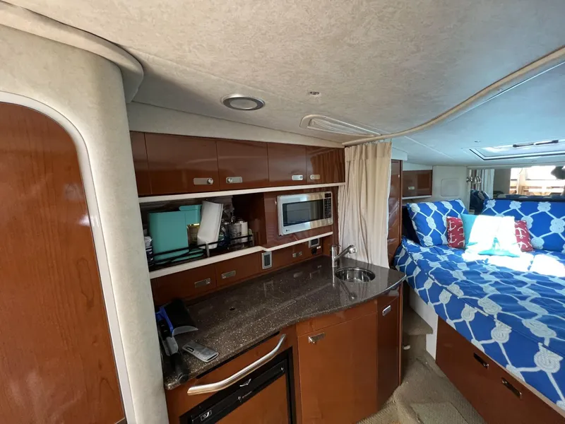 Slide: The Image of Interior of 2012 Sea Ray Sundancer yacht with kitchenette and cozy sleeping area. - 37