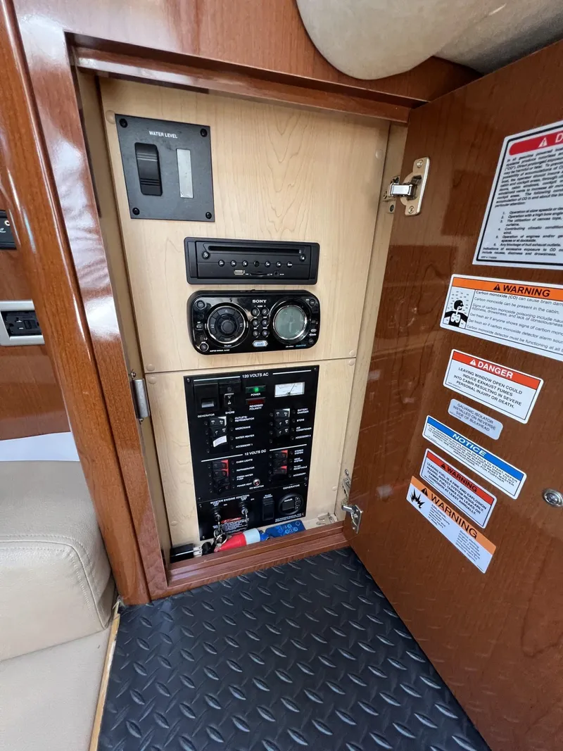 Slide: The Image of Control panel inside 2012 Sea Ray Sundancer boat, featuring switches and warning labels. - 40