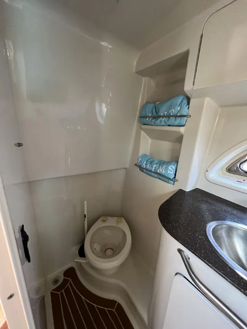 Slide: The Image of 2012 Sea Ray Sundancer bathroom with toilet, sink, and storage shelves. - 46