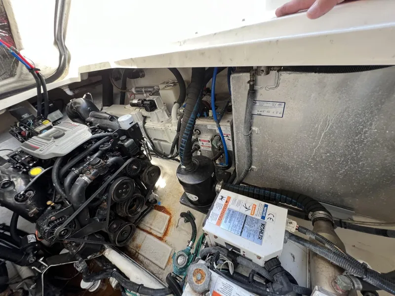 Slide: The Image of Engine compartment of a 2012 Sea Ray Sundancer boat, showcasing mechanical components and wiring. - 49