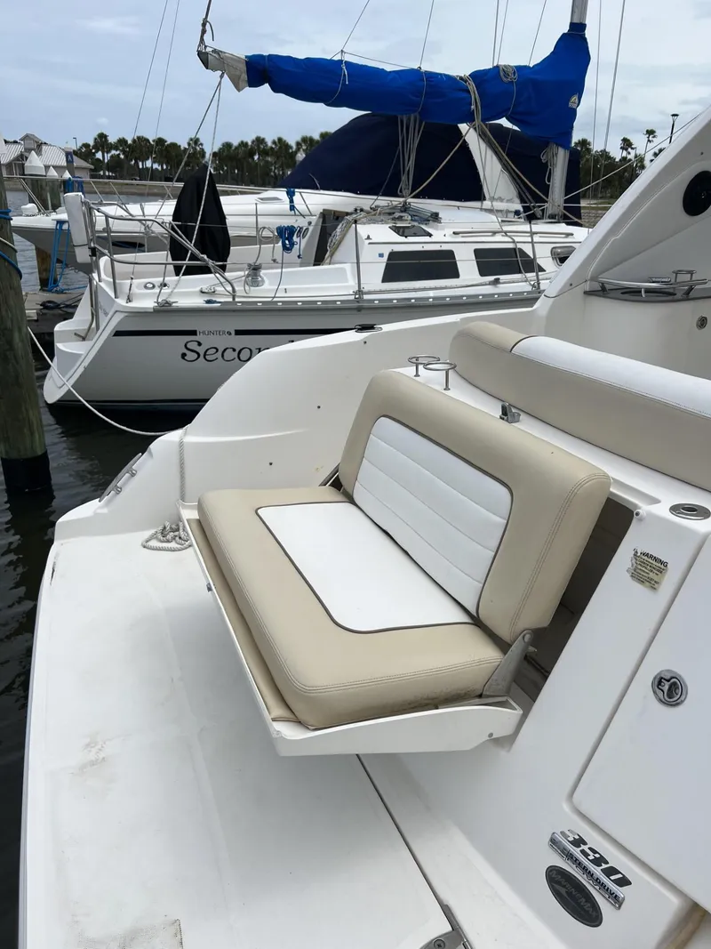 Slide: The Image of 2012 Sea Ray Sundancer boat with beige seating, docked at a marina. - 7