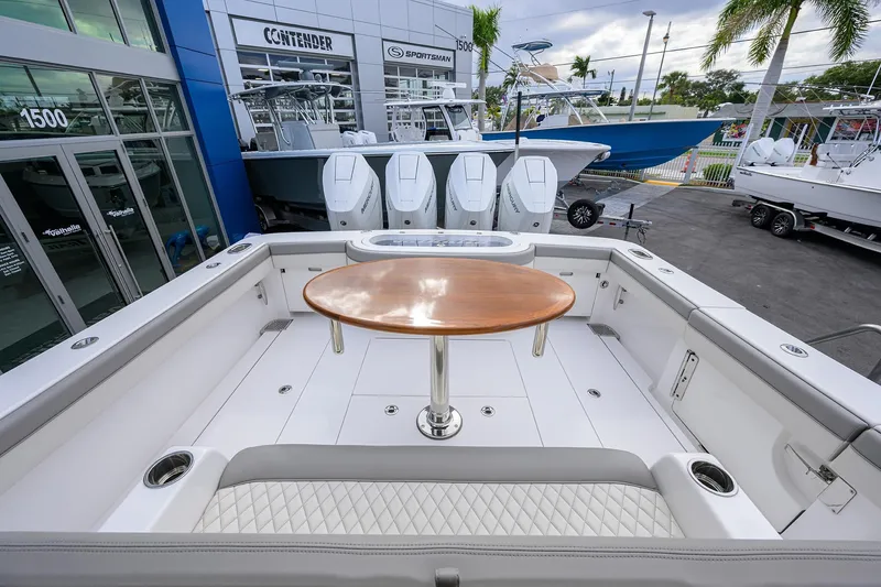Slide: The Image of 2025 Valhalla Boatworks V-41 with sleek deck and wooden table, showcased at a dealership. - 26