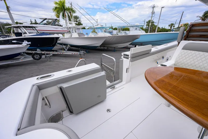 Slide: The Image of 2025 Valhalla Boatworks V-41 interior with seating and wooden table, docked among other boats. - 30