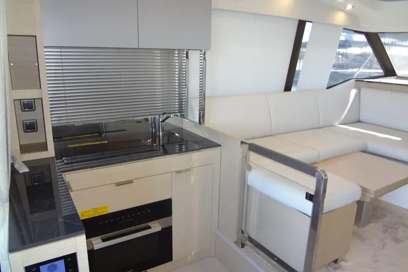 Slide: The Image of 2023 Prestige 420S yacht interior with gray seating and wooden table. - 20