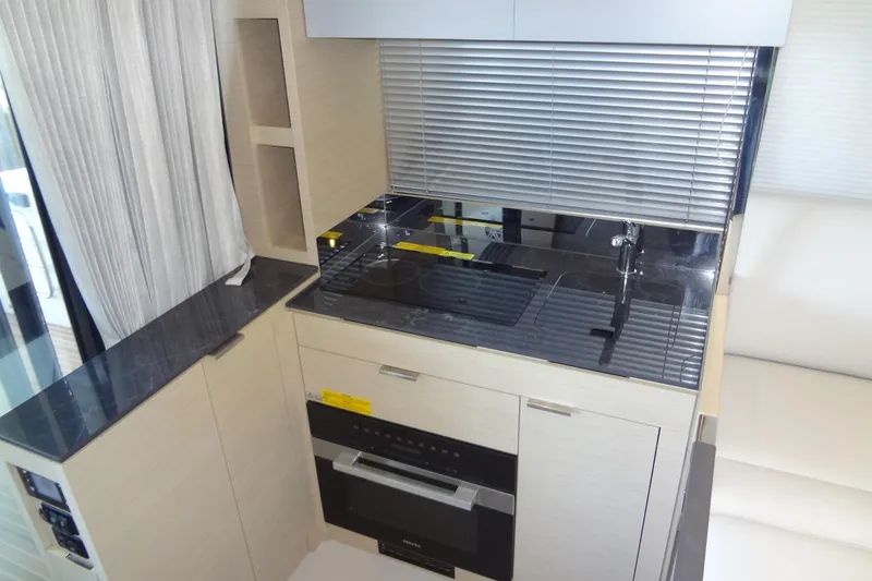 Slide: The Image of 2023 Prestige 420S yacht interior with gray seating and wooden table. - 21