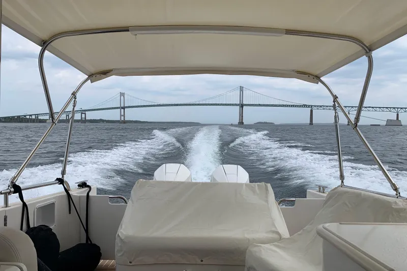 Slide: The Image of 2018 MJM 35z boat cruising under a bridge on a cloudy day. - 2