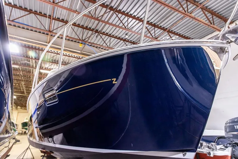 Slide: The Image of 2018 MJM 35z boat in a warehouse, showcasing sleek blue hull design. - 33