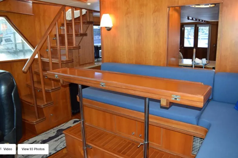 Slide: The Image of Interior of 2002 Grand Alaskan Cockpit Motor Yacht with wooden finishes and blue seating. - 11