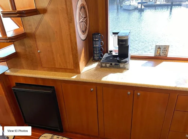 Slide: The Image of 2002 Grand Alaskan Cockpit Motor Yacht interior with wooden cabinetry and coffee maker by window. - 18