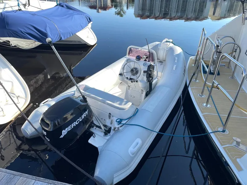 Slide: The Image of Inflatable boat with Mercury outboard motor docked beside a yacht. - 2