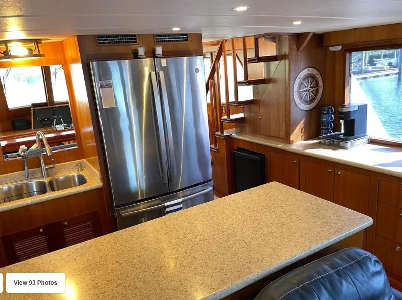 Slide: The Image of Luxurious 2002 Grand Alaskan Cockpit Motor Yacht kitchen with modern appliances and elegant wood finishes. - 23
