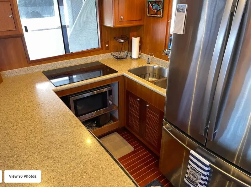 Slide: The Image of Luxurious kitchen in 2002 Grand Alaskan Cockpit Motor Yacht with modern appliances and wood cabinetry. - 24