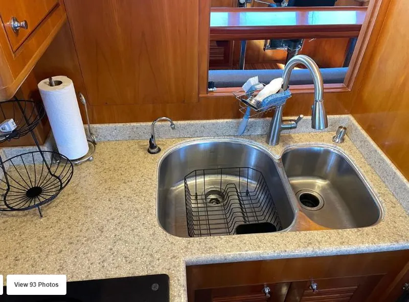 Slide: The Image of Kitchen sink area in 2002 Grand Alaskan Cockpit Motor Yacht with granite countertop and stainless steel fixtures. - 26