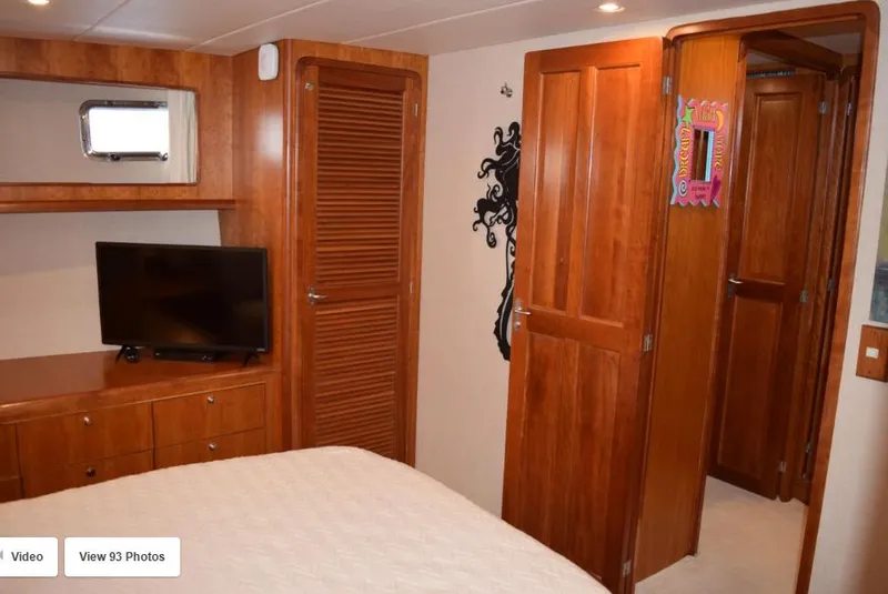 Slide: The Image of 2002 Grand Alaskan Cockpit Motor Yacht interior with wood paneling, TV, and cozy bedroom. - 42