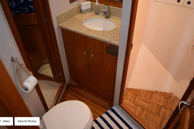 Slide: The Image of 2002 Grand Alaskan Cockpit Motor Yacht bathroom with sink, toilet, and wooden flooring. - 48