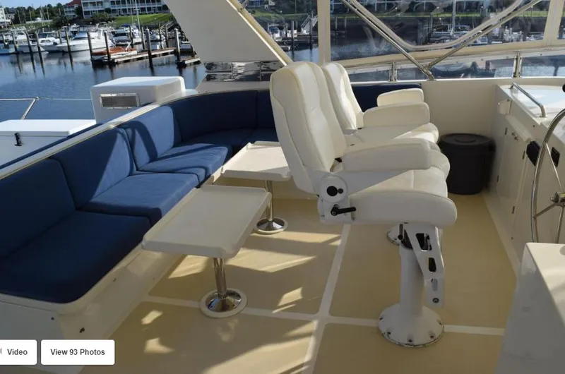 Slide: The Image of 2002 Grand Alaskan Cockpit Motor Yacht interior with seating and helm, docked at marina. - 6