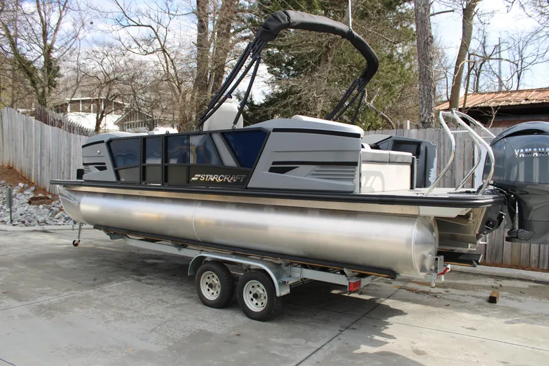 The Image of 2026 Starcraft VX 24 Q DH pontoon boat on trailer in driveway. - 1