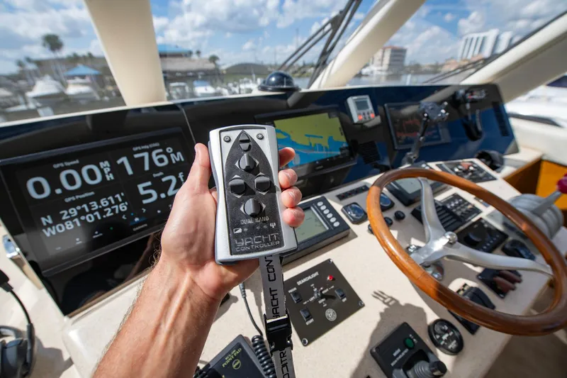 Slide: The Image of Hand holding remote at helm of 2003 Ocean Yachts 62 Super Sport EB. - 25
