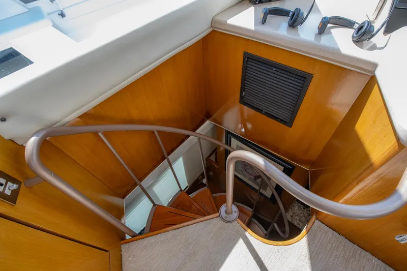 Slide: The Image of Staircase on 2003 Ocean Yachts 62 Super Sport EB, featuring wooden paneling and modern design. - 28
