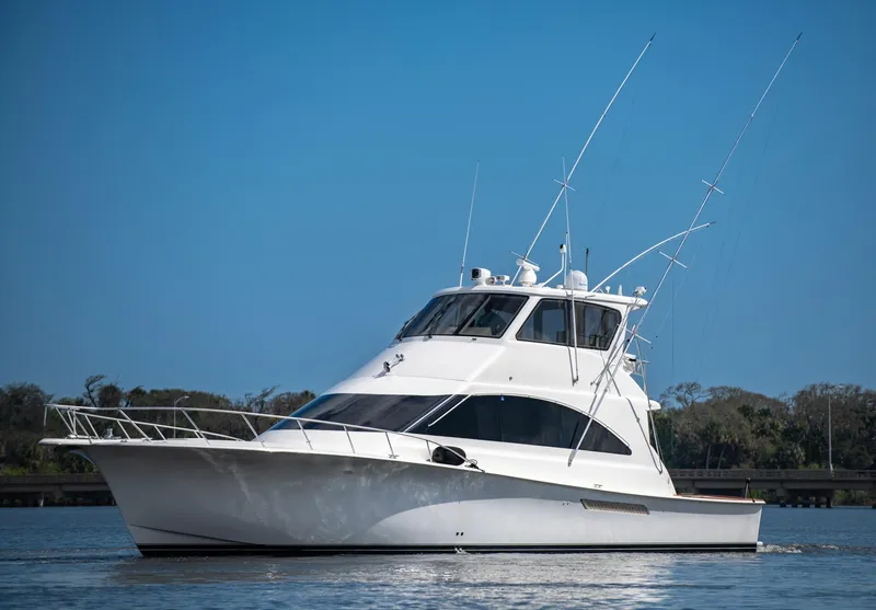 The Image of 2003 Ocean Yachts 62 Super Sport EB on calm water, showcasing sleek design and fishing capabilities. - 0