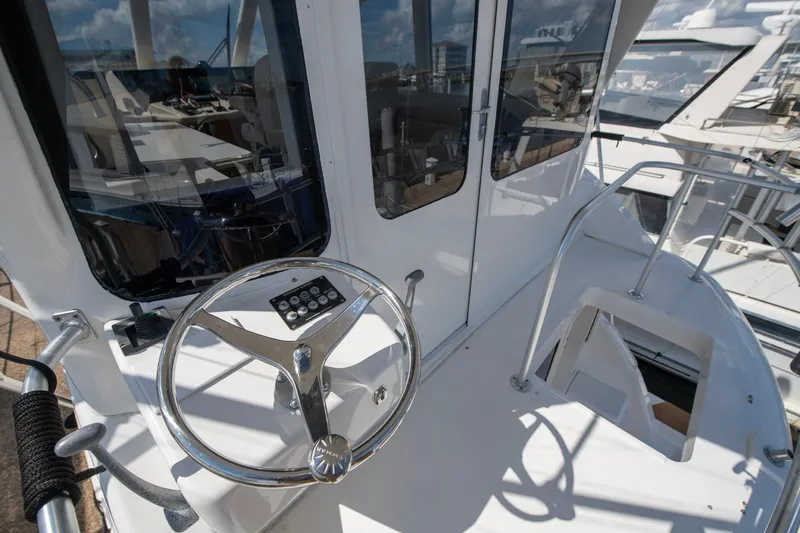 Slide: The Image of 2003 Ocean Yachts 62 Super Sport EB helm with steering wheel and controls. - 13
