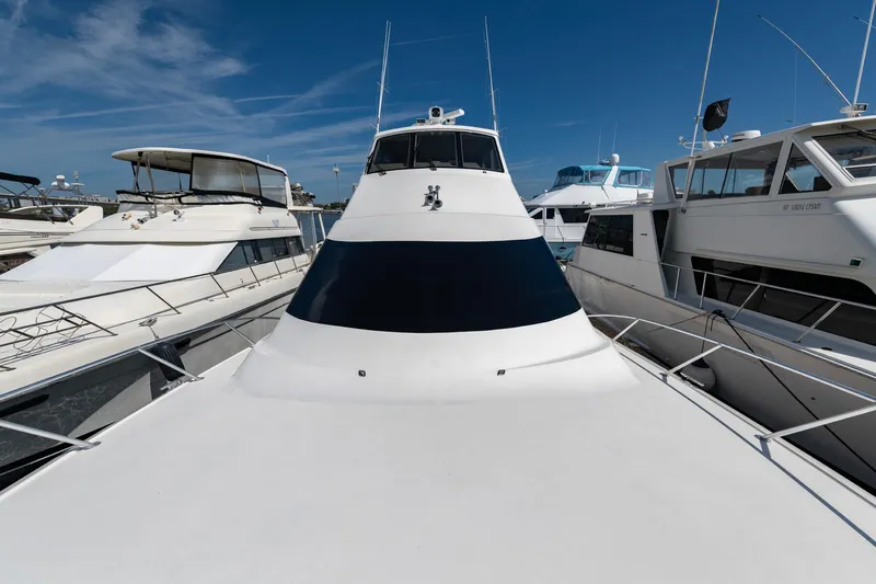 Slide: The Image of 2003 Ocean Yachts 62 Super Sport EB docked among other boats under a clear blue sky. - 3