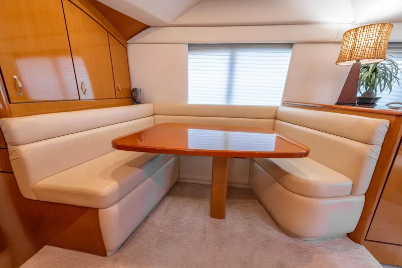 Slide: The Image of Luxurious dining area in 2003 Ocean Yachts 62 Super Sport EB with plush seating and wooden table. - 35