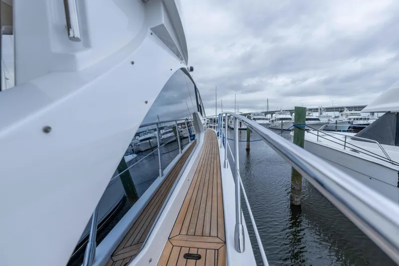 Slide: The Image of 2015 Azimut 55S yacht docked, showcasing sleek design and wooden deck. - 50