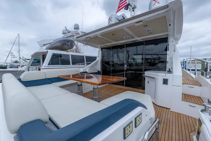 Slide: The Image of 2015 Azimut 55S yacht with spacious deck, seating, and wooden table. - 53