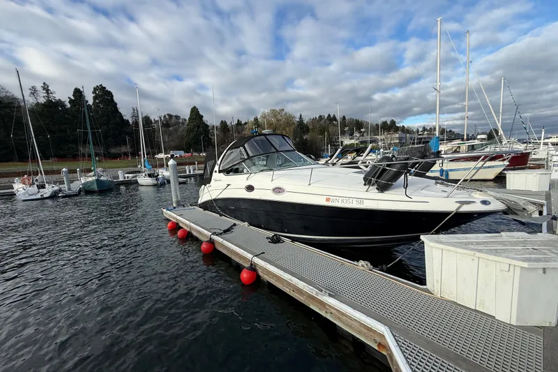 The Image of 2007 Sea Ray 280 Cuddy Cabin docked at a marina under cloudy skies. - 1