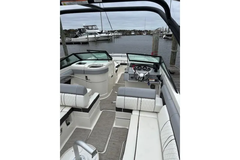 Slide: The Image of 2016 Sea Ray 270 Sundeck interior with seating and steering, docked at marina. - 3